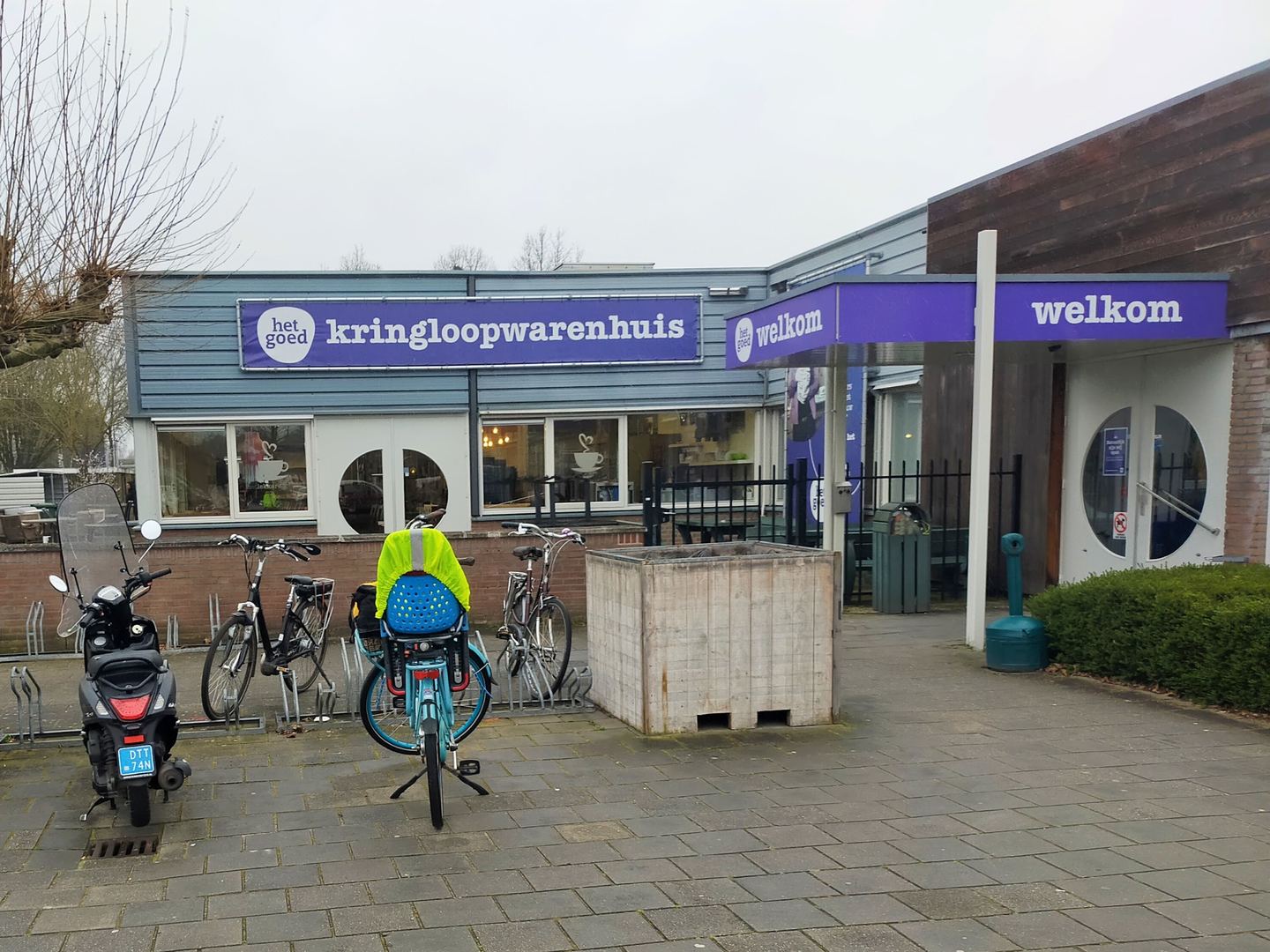 Ingang van Kringloopwarenhuis Het Goed met paarse naamborden