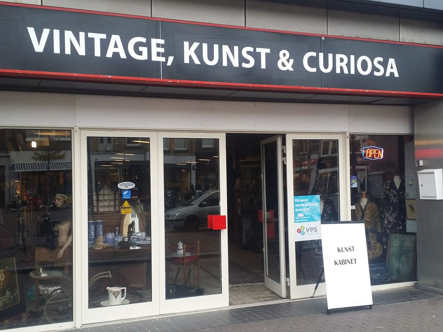 Winkelpui van Het Kunstkabinet met het naambord Vintage, Kunst & Curiosa en een open deur