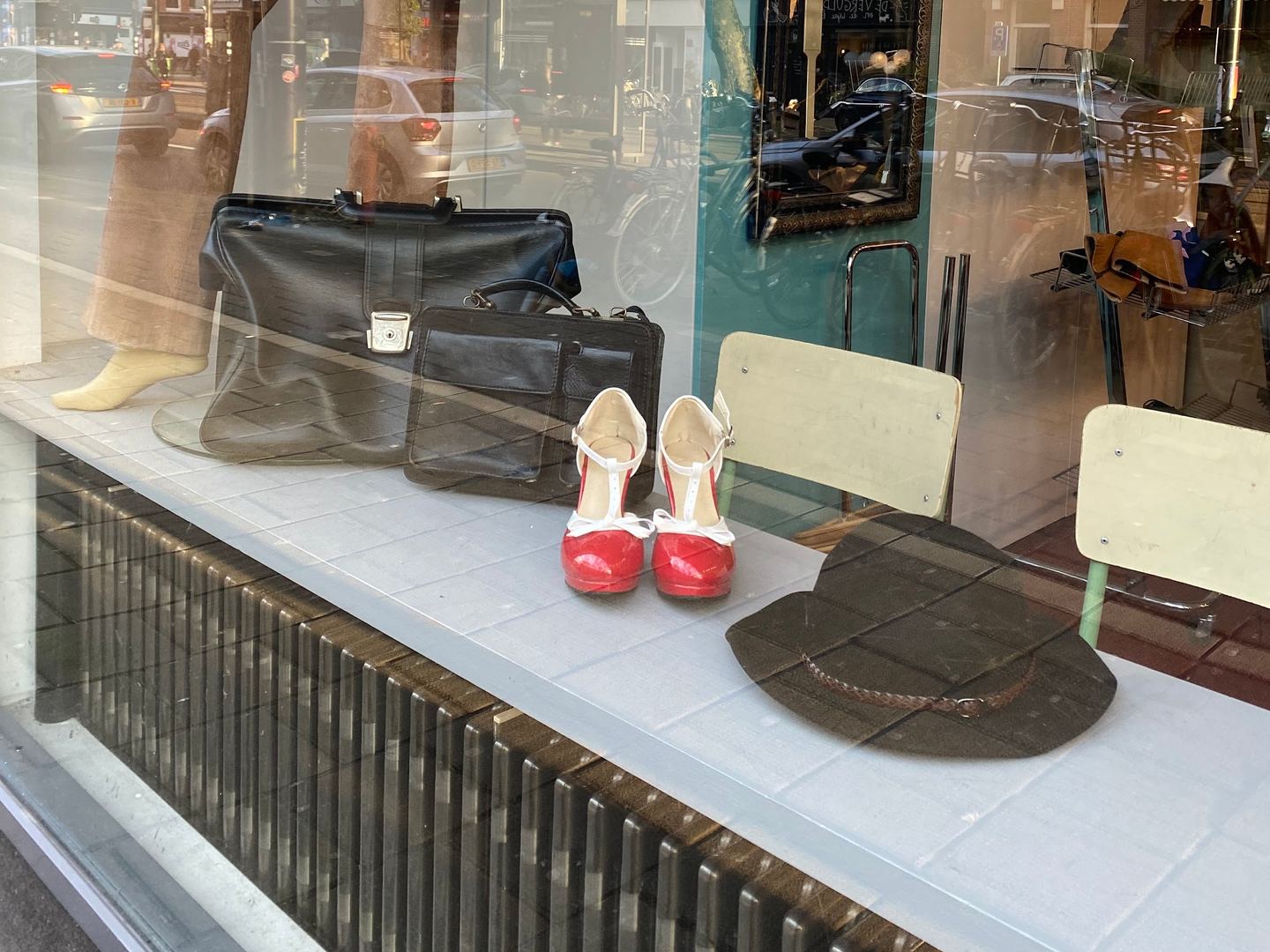 Etalage van Ink Vintage met leren tassen, rode pumps en een hoed