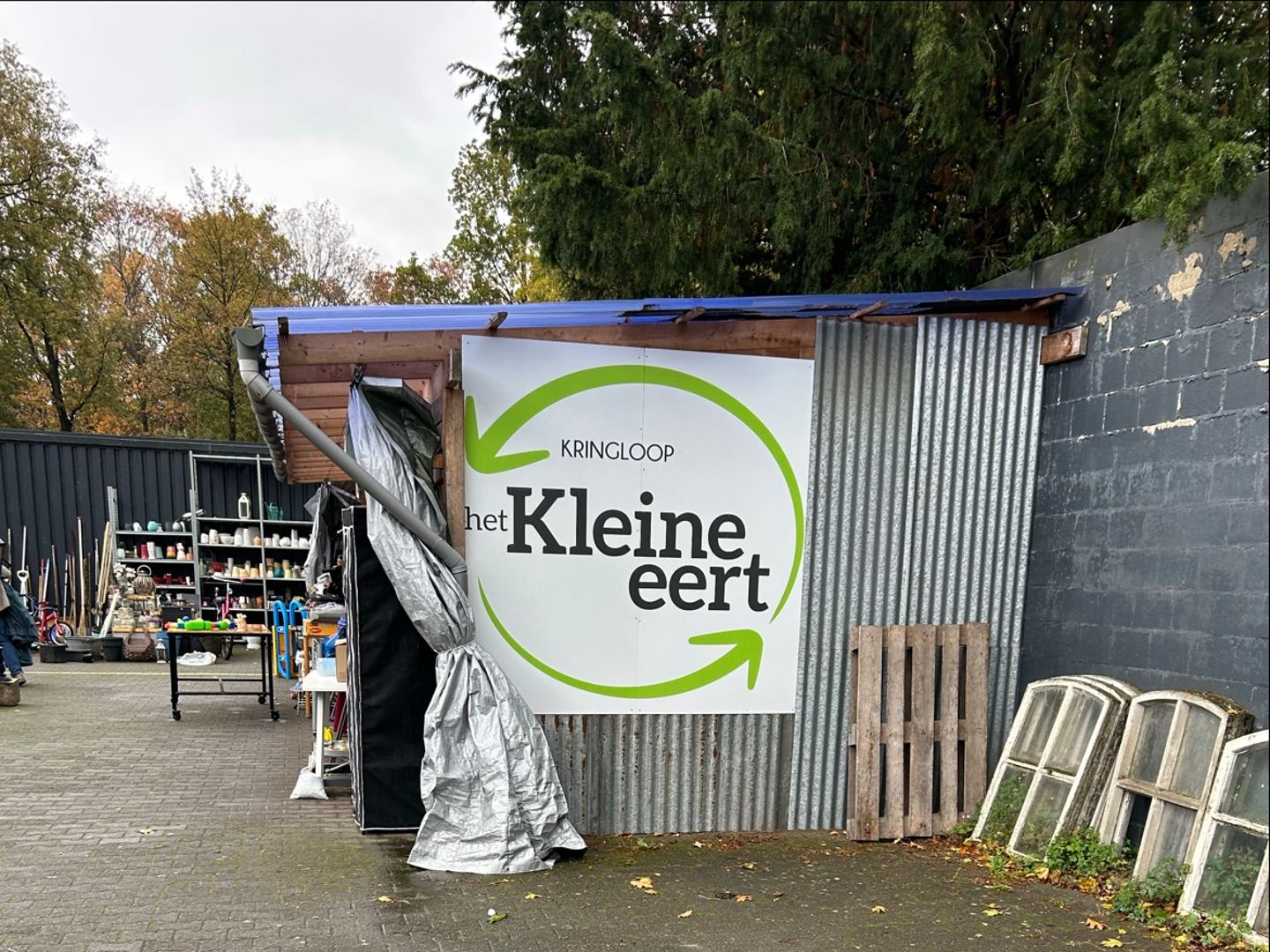 Naambord van Kringloop Het Kleine Eert bij de ingang van de winkel