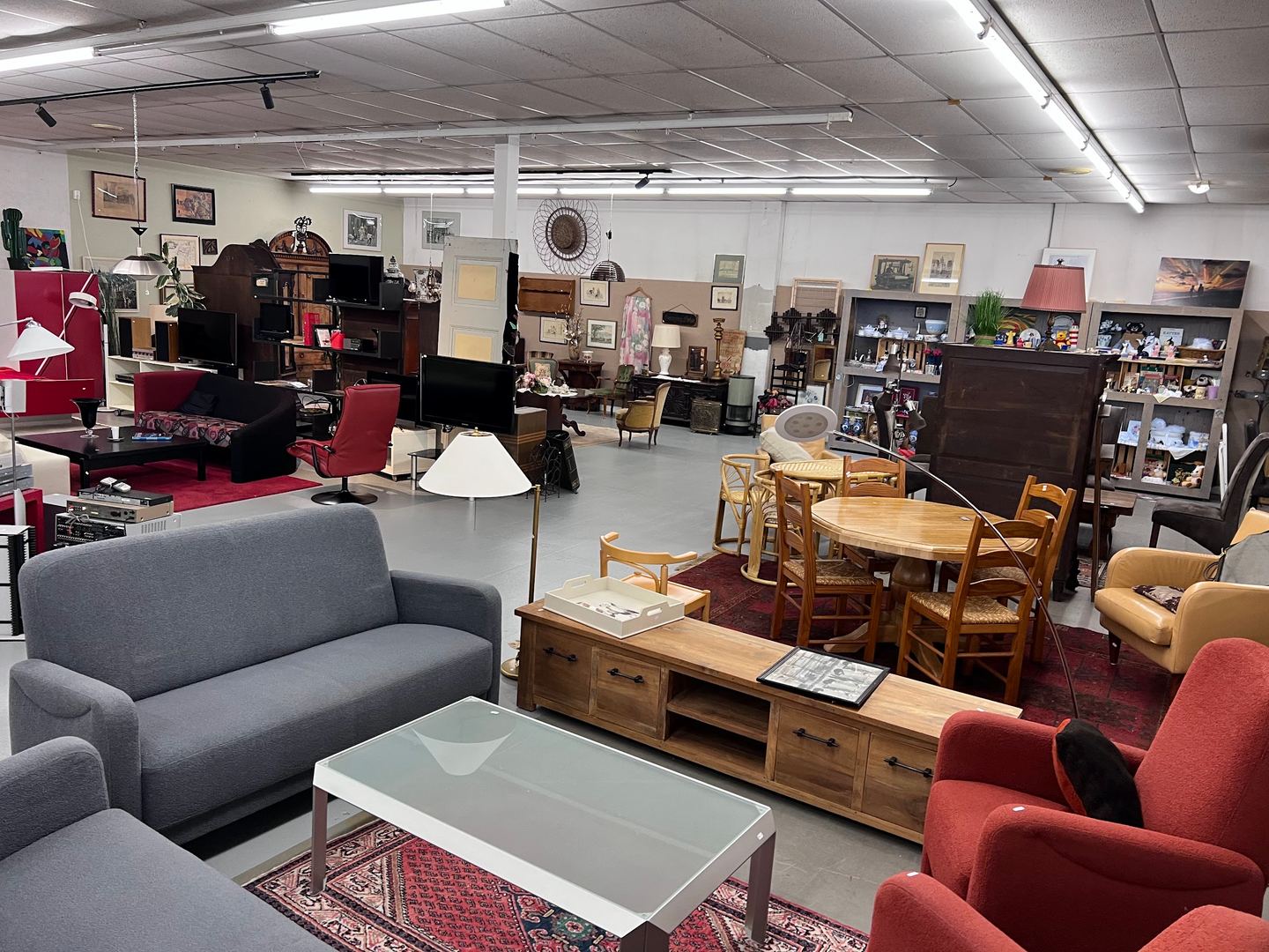Interieur van Kringloop Vintage & More met banken, fauteuils, tafels en kasten in de winkelruimte