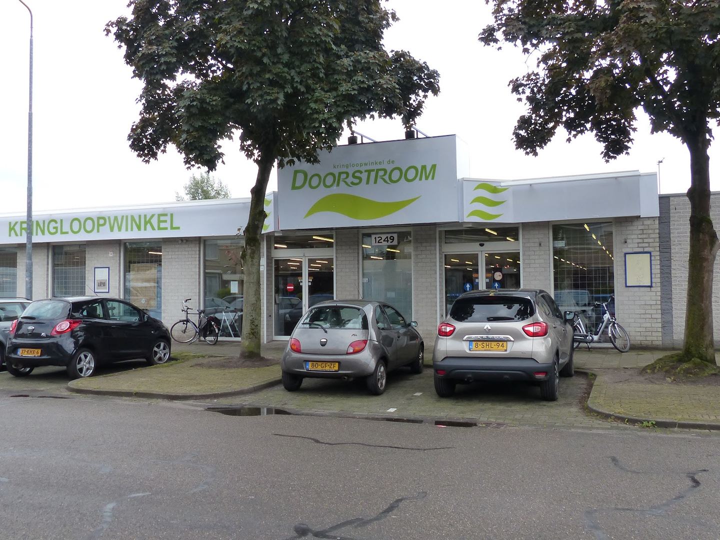 Exterior view of Kringloopwinkel De Doorstroom showing the building facade and signage.