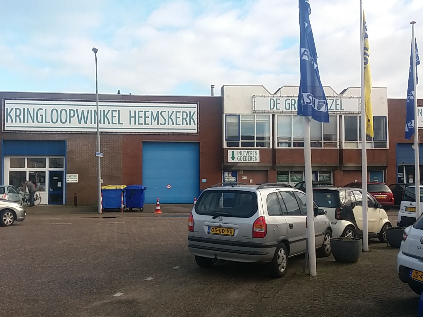 Bedrijfspand van Kringloopwinkel De Groene Ezel met het naambord en de ingang