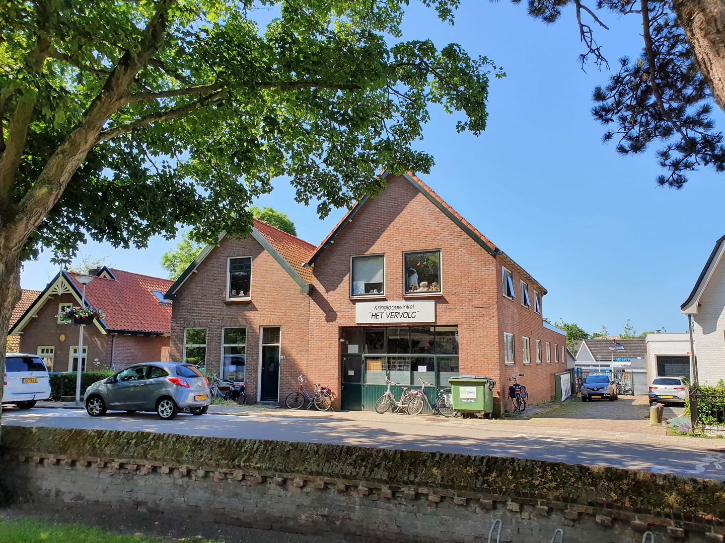 Gevel van Kringloopwinkel Het Vervolg met naambord boven de ingang