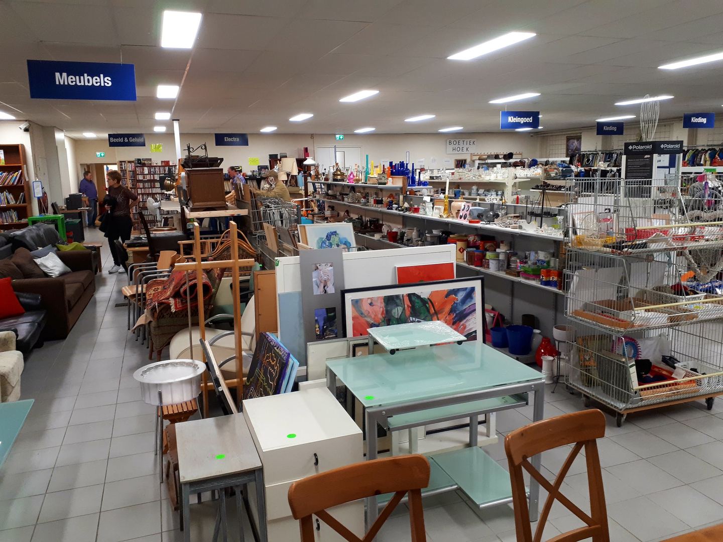 Winkelvloer van Kringloopwinkel Vincentius met meubels, schilderijen en rekken vol huisraad