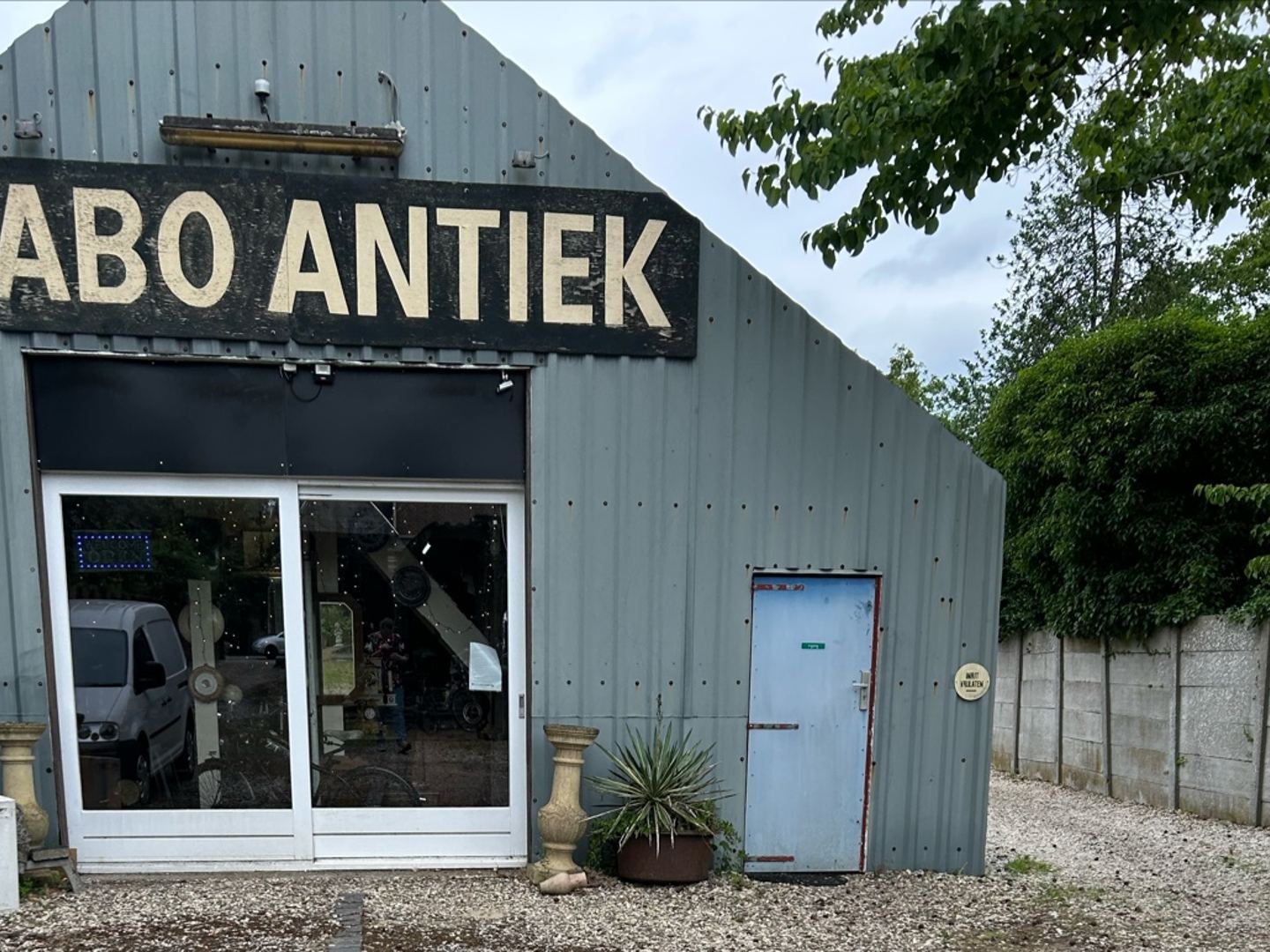 Loods van Mabo Antiek met groot naambord boven de glazen schuifdeuren