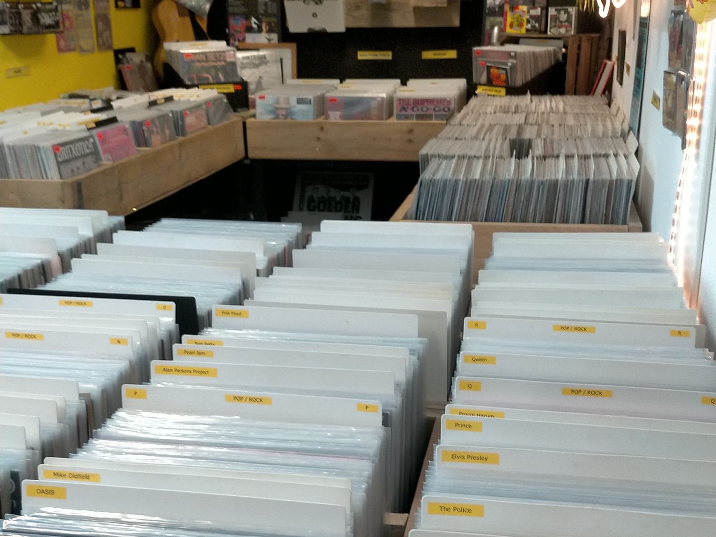 Bakken vol vinylplaten in de winkel van Mono's Platen & CD's met posters aan de wand