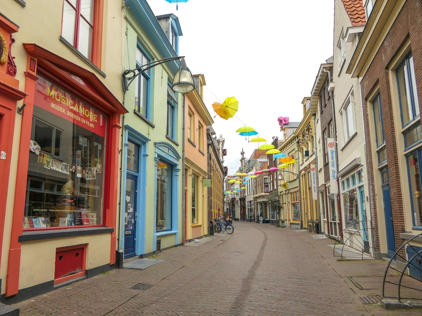 Rode winkelpui van Musicamore met etalage, in een straat met kleurrijke gevels