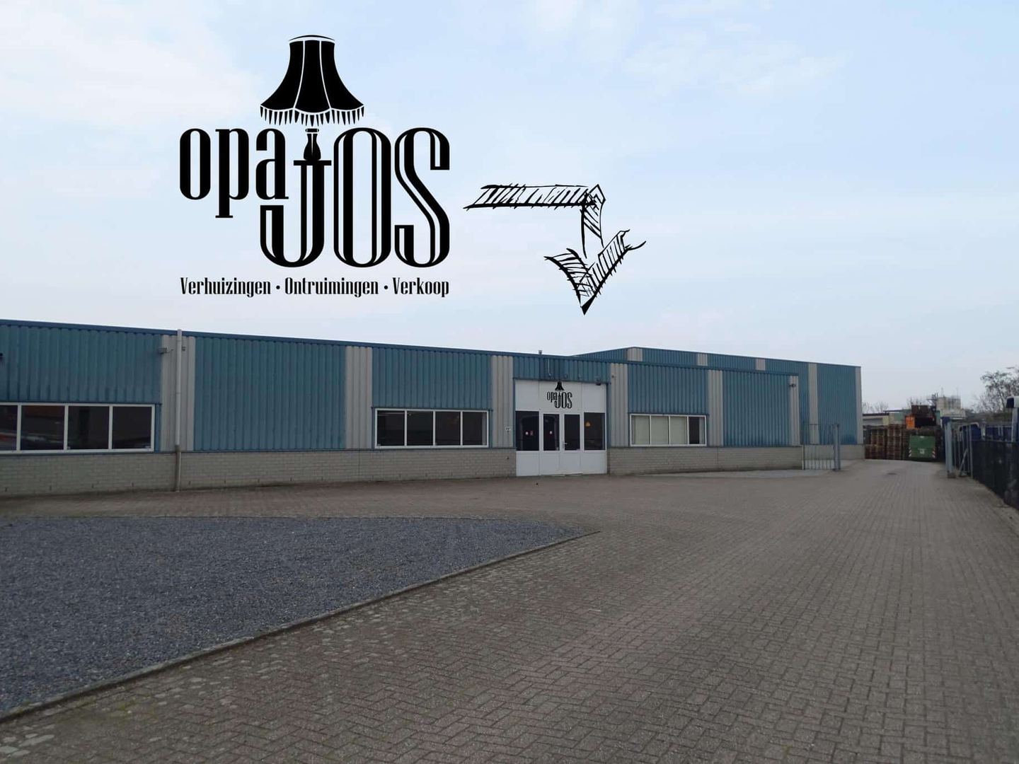 A wide shot of the Opa Jos storefront, showing a long, single-story building with a blue and white corrugated metal facade and a large sign that reads 'opa jos' with a lamp icon.