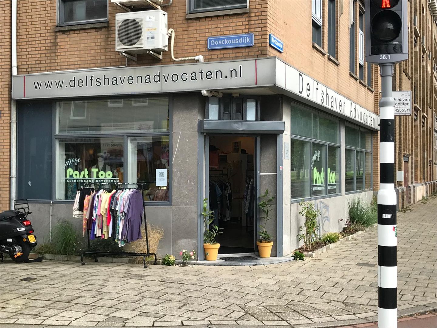 Hoekpand van Past Too met de winkelnaam op het raam en een kledingrek buiten