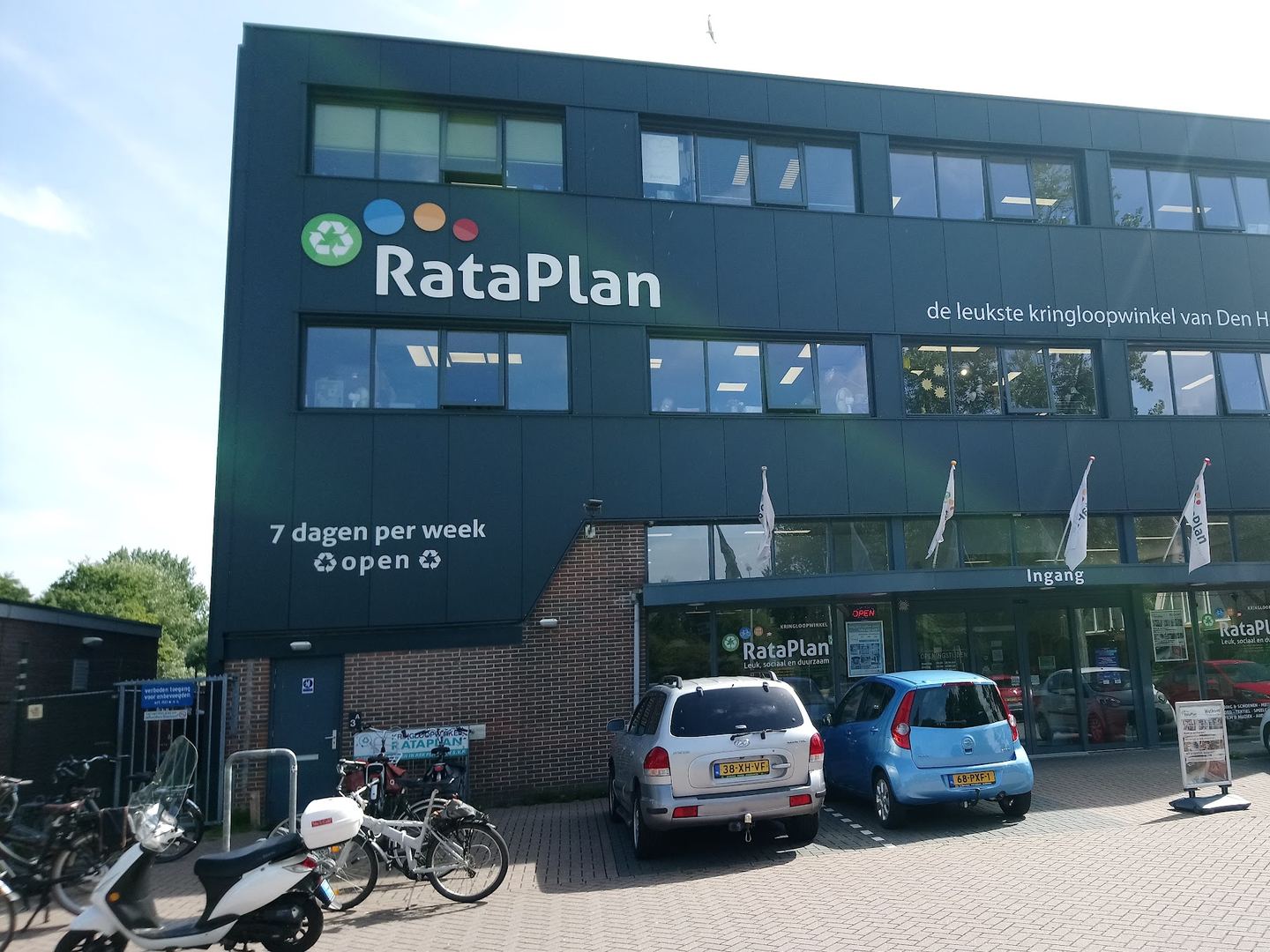 Gevel van RataPlan Den Helder met naambord en parkeerplaatsen voor de ingang