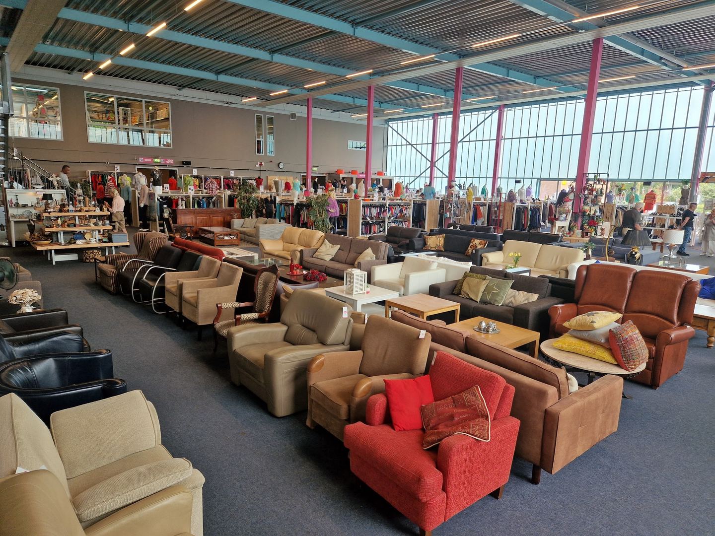 Banken, fauteuils en kledingrekken in de winkelhal van RataPlan Purmerend