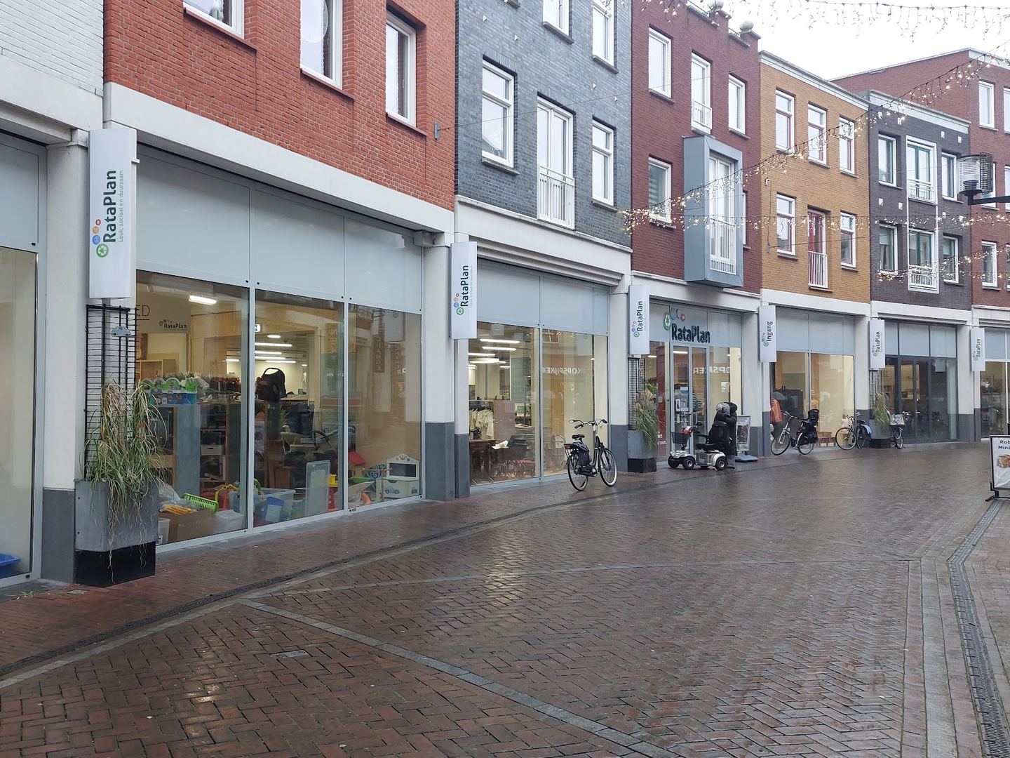 Winkelpui van Kringloopwinkel RataPlan Spijkenisse met het logo boven de ingang en etalages met meubels
