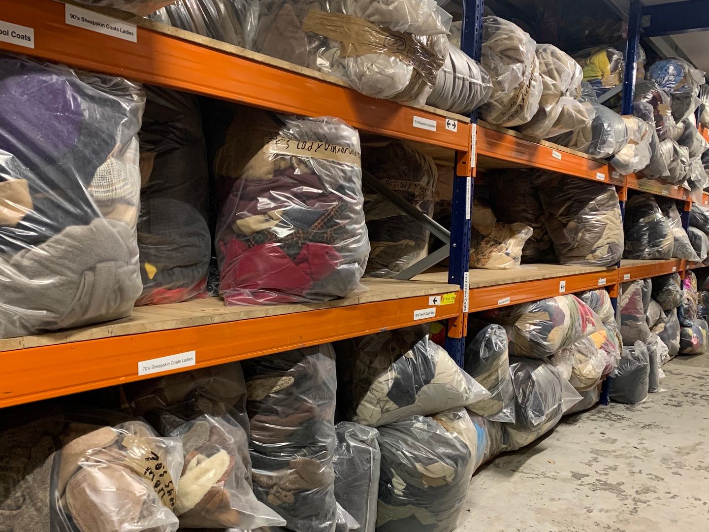 Magazijn van Rerags met hoge stellingen vol balen tweedehands kleding