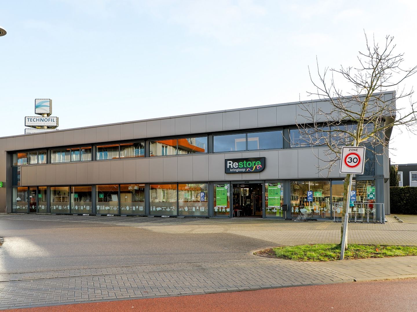 Gevel van Restore Kringloop Ede met groene naamletters boven de ingang