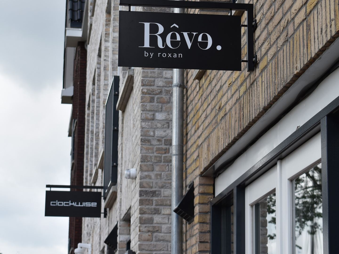 Zwart naambord van Rêve by roxan aan de gevel van de boetiek
