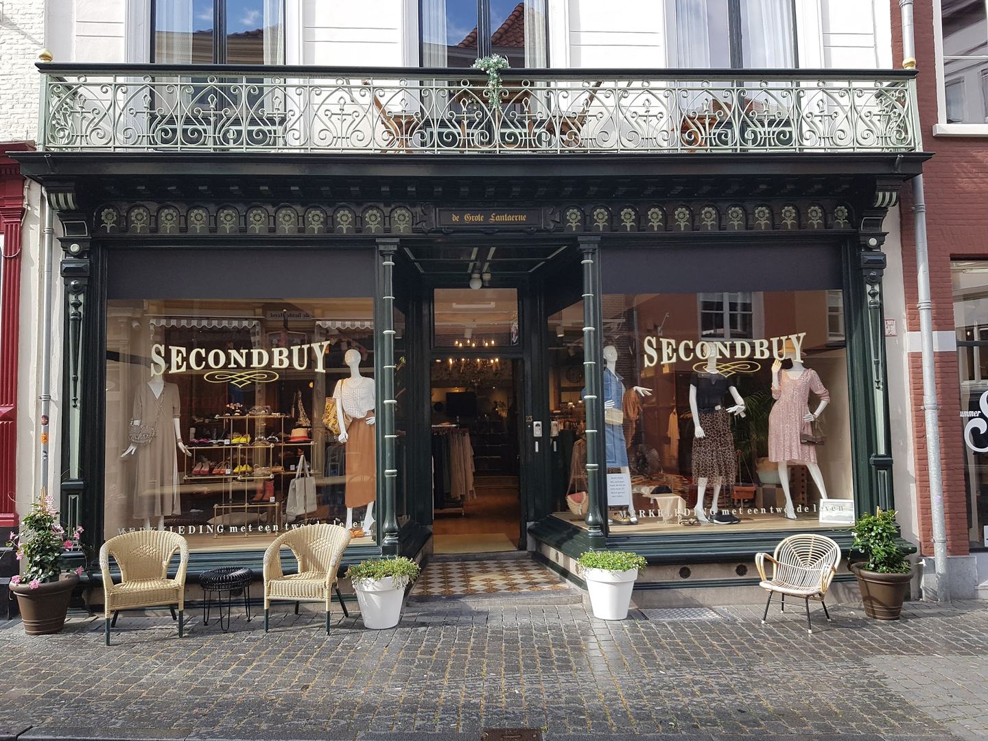 Historische winkelpui van Secondbuy met balkon en etalages met dameskleding