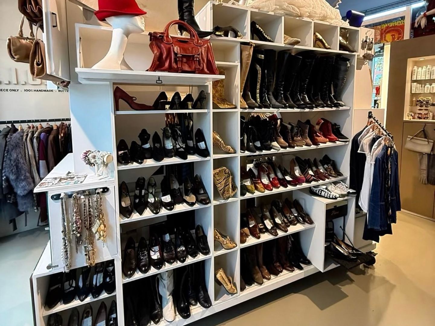 Interieur van SHOWROOM41 met een verrijdbare displaykast vol schoenen, tassen en hoeden