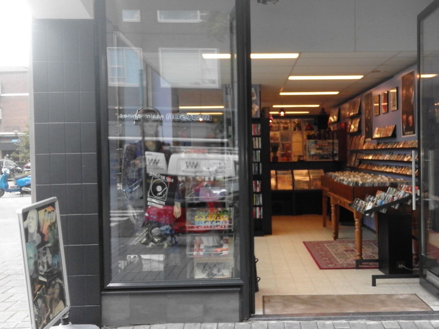 Winkelpui van Songs For Sale met open deur en bakken vol platen achter het raam