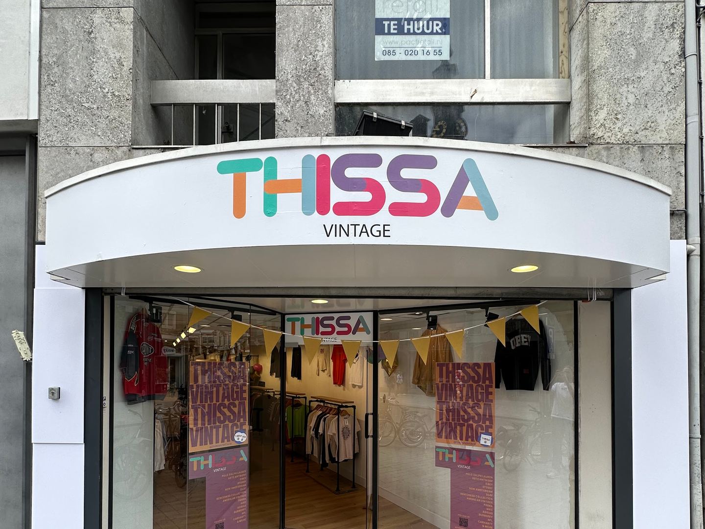 Winkelpui van Thissa Vintage met rekken vintage kleding achter de open glazen deuren