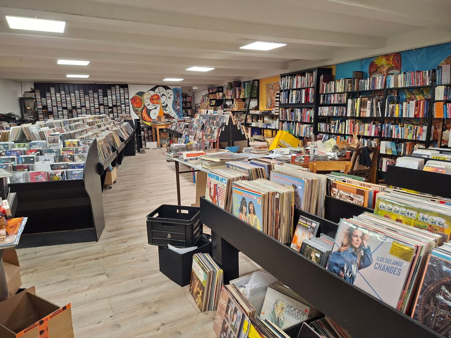 Interieur van Tonko Records & Books met bakken vol lp's en kasten met cd's en boeken