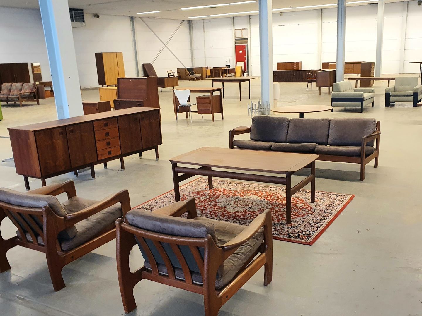 Grote hal van Vintage Design Store met teakhouten dressoirs, banken en fauteuils