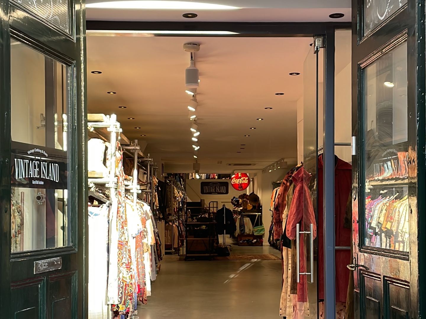 Ingang van Vintage Island met rode loper en kleding op rekken