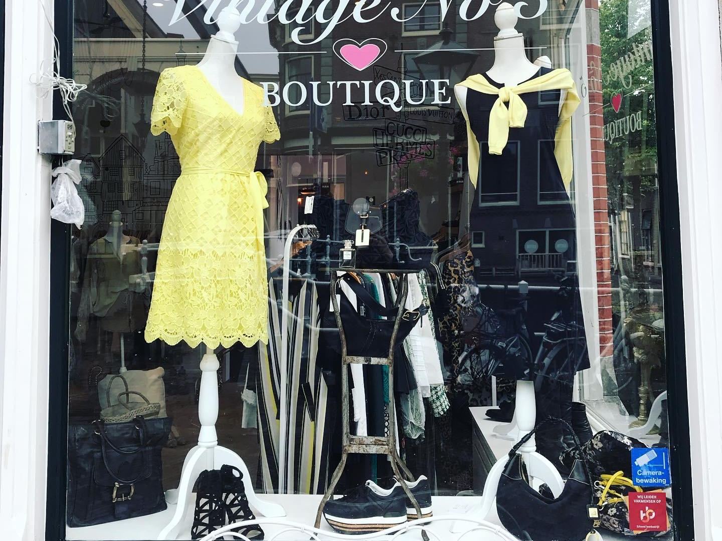 Etalage van Vintage Nō 5 met paspoppen in vintage kleding en de winkelnaam op het raam