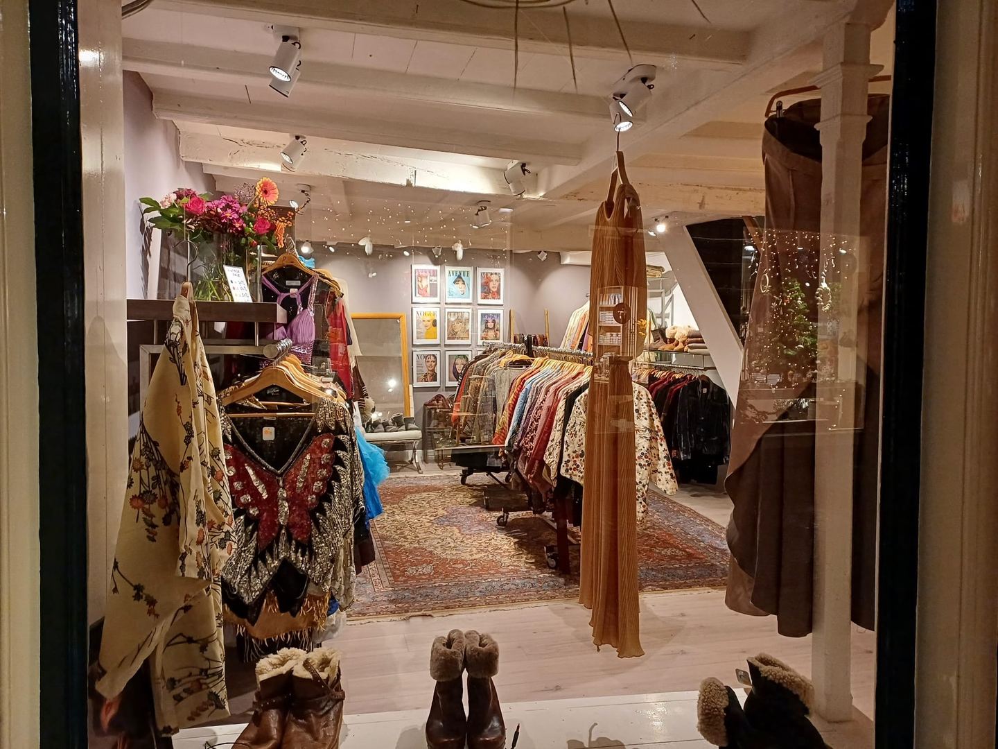 Blik door de deur van Vintage Treasure op rekken met vintage kleding en kimono's