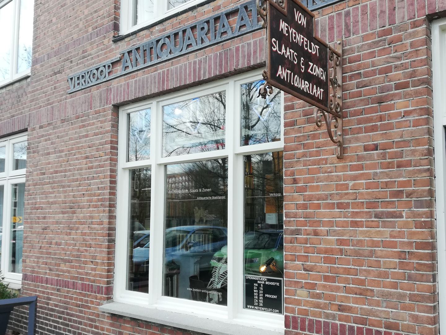 Bakstenen gevel met uithangbord en opschrift Antiquariaat van Von Meyenfeldt, Slaats & Zonen