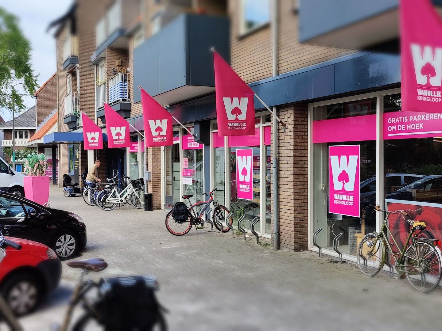 Winkelpui van Wawollie Kringloop Almelo met roze vlaggen langs de gevel