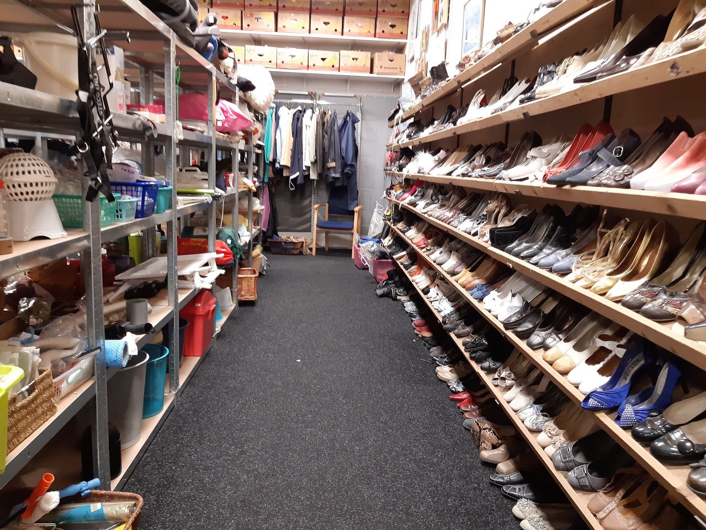Gangpad met rekken tweedehands schoenen en kleding in Winkel van Sinkel Venray