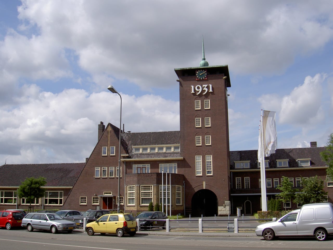 Het bakstenen hoofdgebouw van de Brabanthallen met de toren en het jaartal 1931.