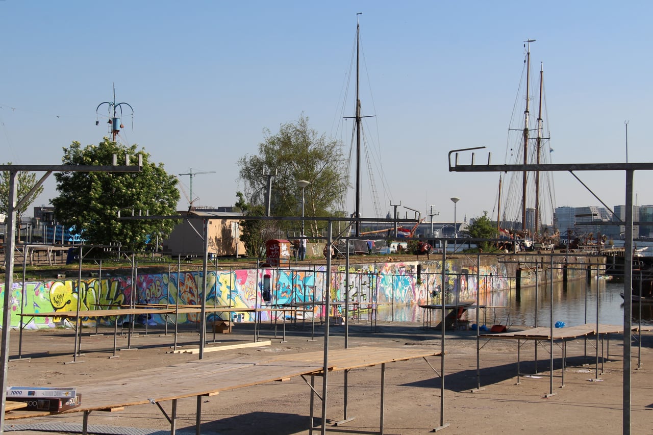 Lege marktkramen aan het water op de NDSM-werf na afloop van de markt in mei 2016.